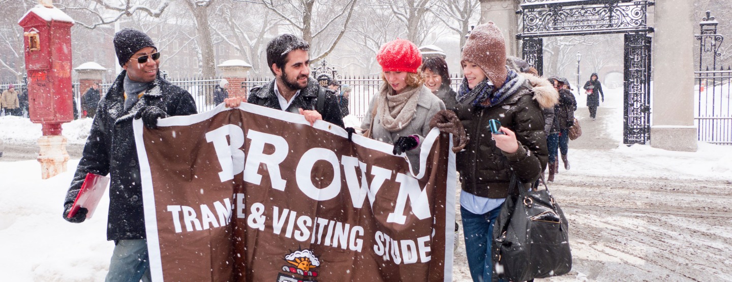 Visiting students holding banner.